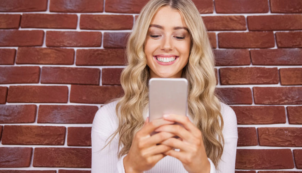 Woman smiling and using a smartphone